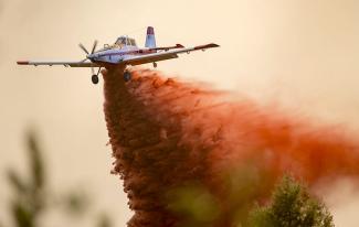 Plane dropping red fire retardant.jpg Plane dropping red fire retardant