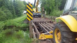 Crane working on a wooden bridge within the forest.jpg Crane working on a wooden bridge within the forest