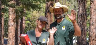 Volunteer hosts smiling and waving.