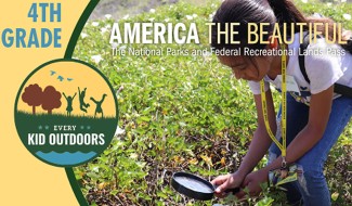 Every Kid Outdoors Pass shows a young girl looking through a magnifying glass at something growing in a meadow.