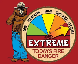Smokey Bear sign with the arrow on red "Extreme" fire danger level.