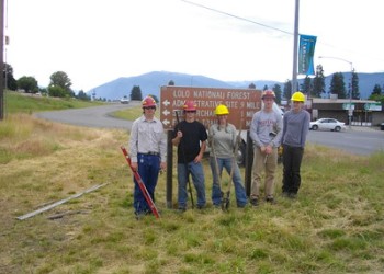 Group of youth standing near Forest Service sign