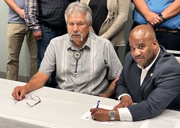 Two men signing a document.
