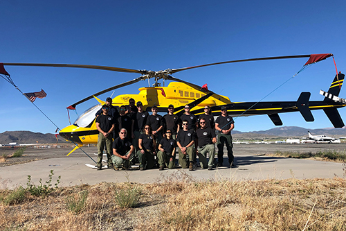 Helitack crew members standing in front of helicopter
