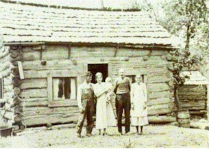 family in front of cabin