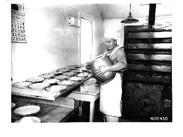 CCC enrollee baker Toivo Maki putting meringue on lemon pies which he has baked for the enrollees at Gegoka CCC camp.