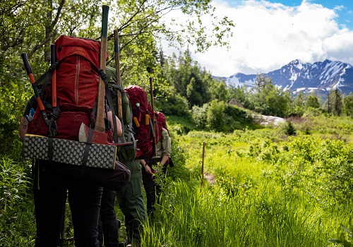 A trail crew heads down a trail with full packs.