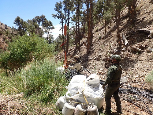 Forest Service law enforcement officers prepare trash to be evacuated out of a marijuana grow site by helicopter on the Inyo National Forest in 2022. 