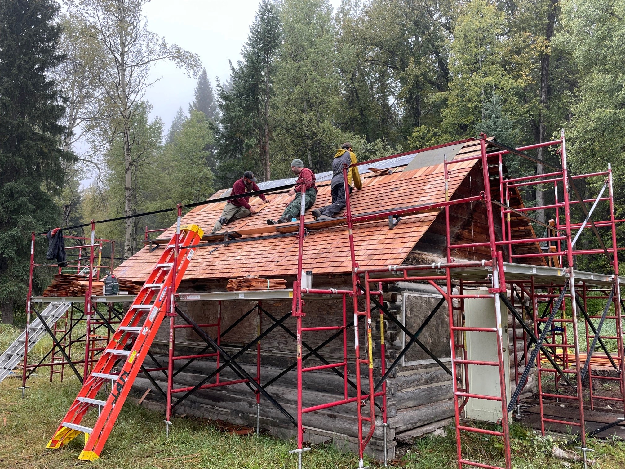 Workers replace roof shingles on Ford Schoolhouse