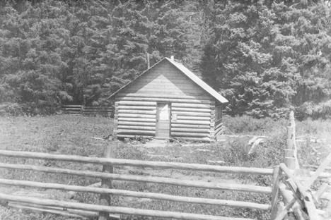 A historical photo of Ford Schoolhouse. A wooden schoolhouse stands in the middle of a field.