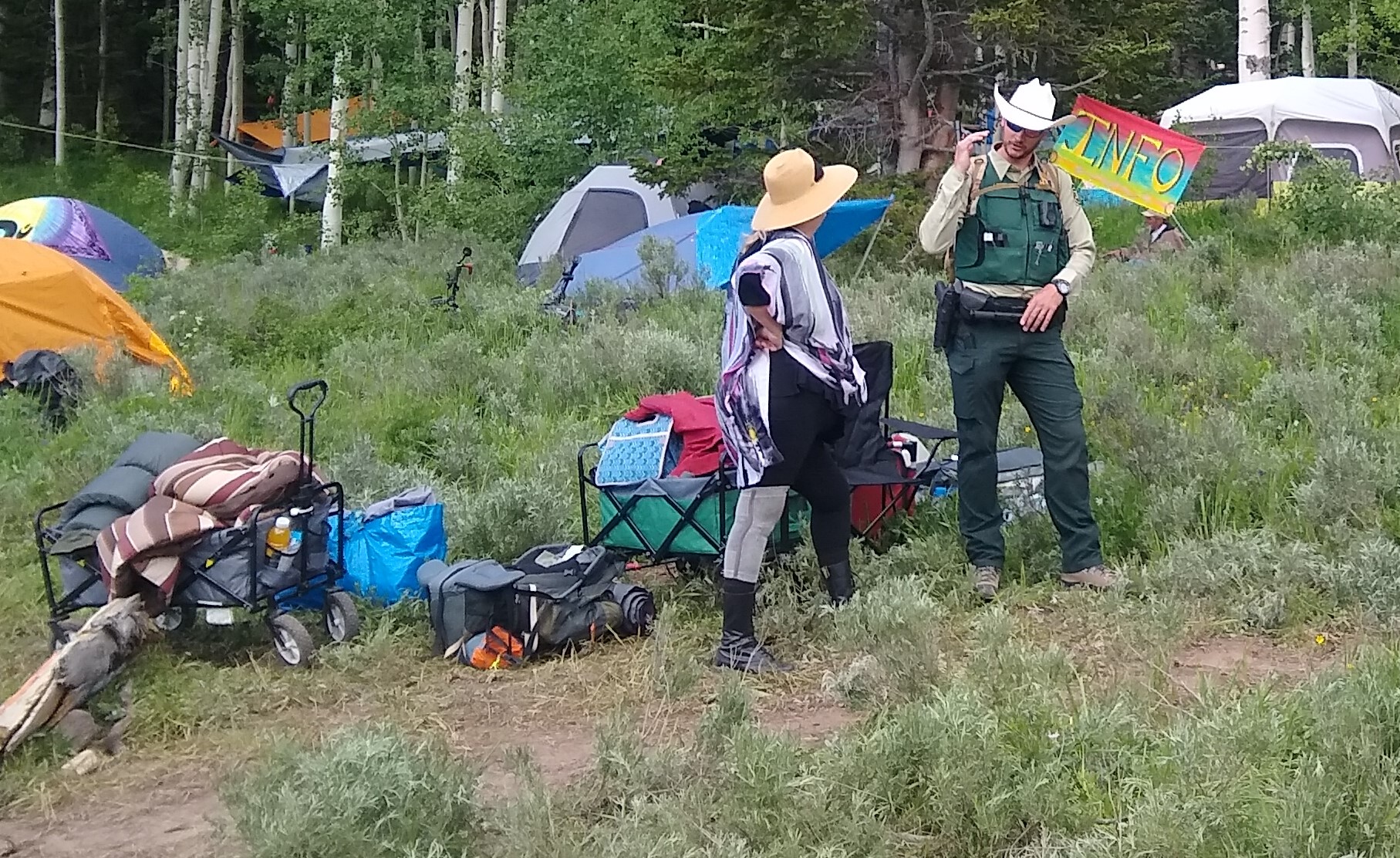 A Forest Service Law Enforcement Office talking to a member of the Rainbow Gathering.