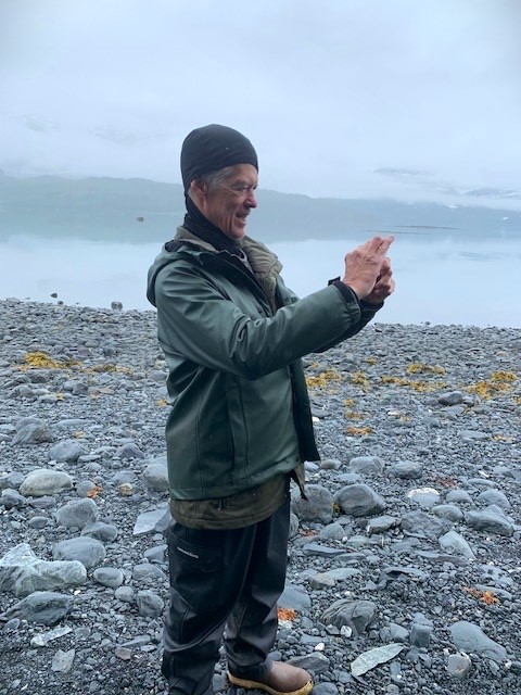 Keith Boggs stands on a rocky beach with misty sky in Prince William Sound.