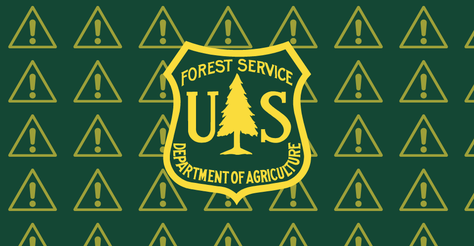 The Forest Service insignia with warning signs in the background.