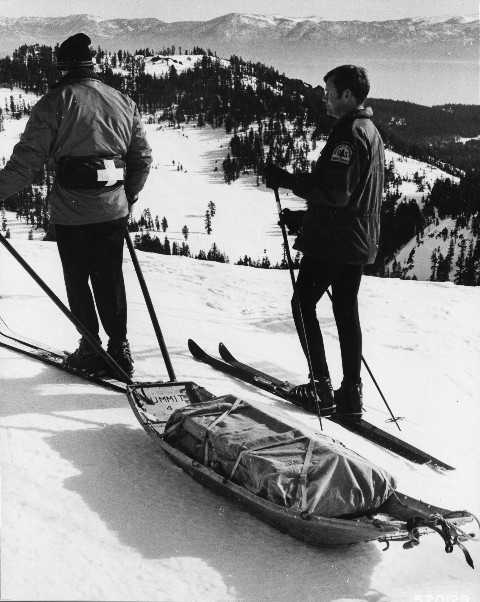 A black and white photo of two skiers