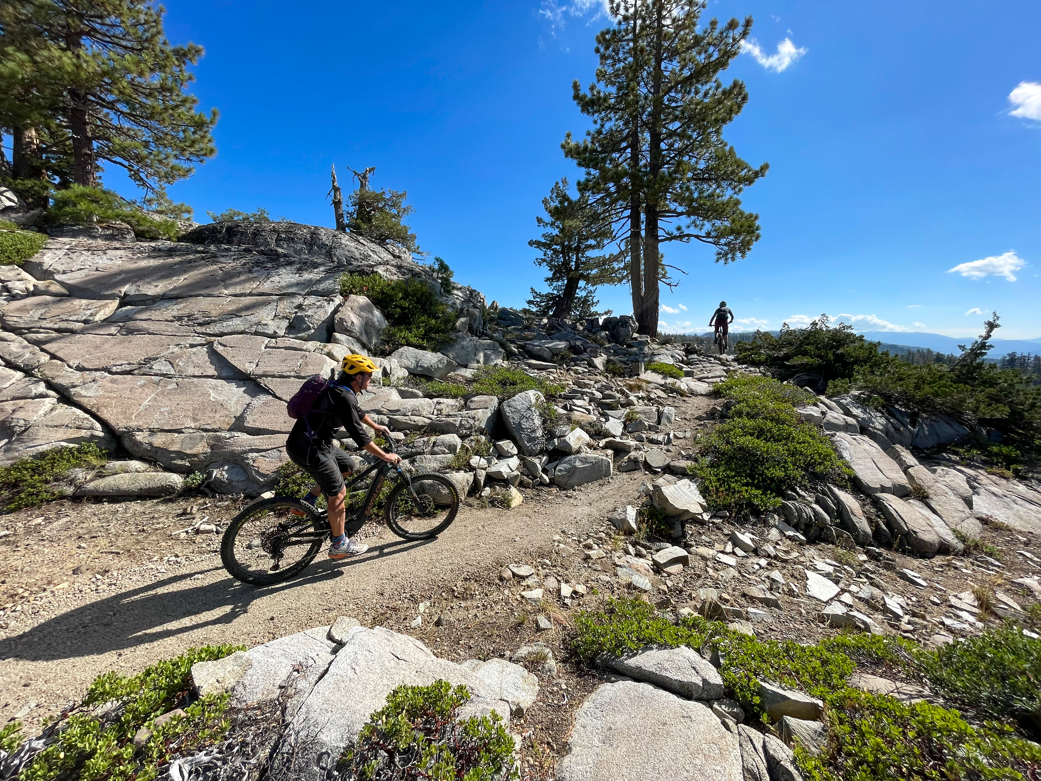 Two mountain bikers traverse rocky terrain.