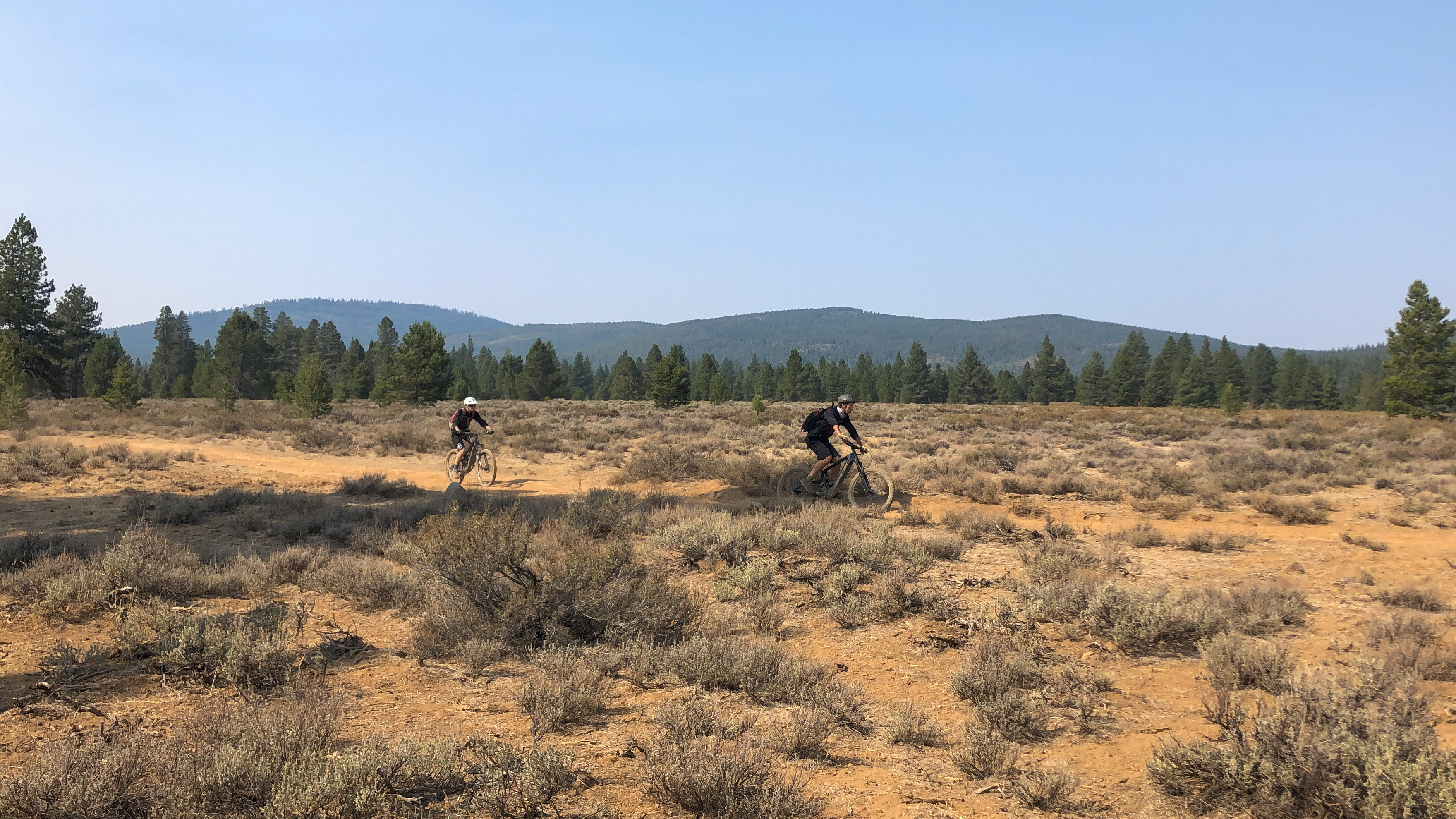 Two mountain bikers in a high desert landscape.