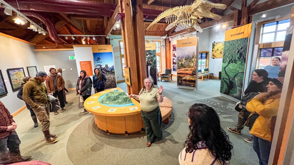 Inside the Southeast Alaska Discovery Center a ranger explains some exhibits to a crowd.