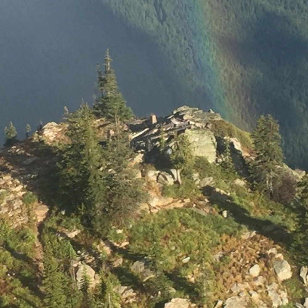 Aerial view of a mountain peak with a rainbow