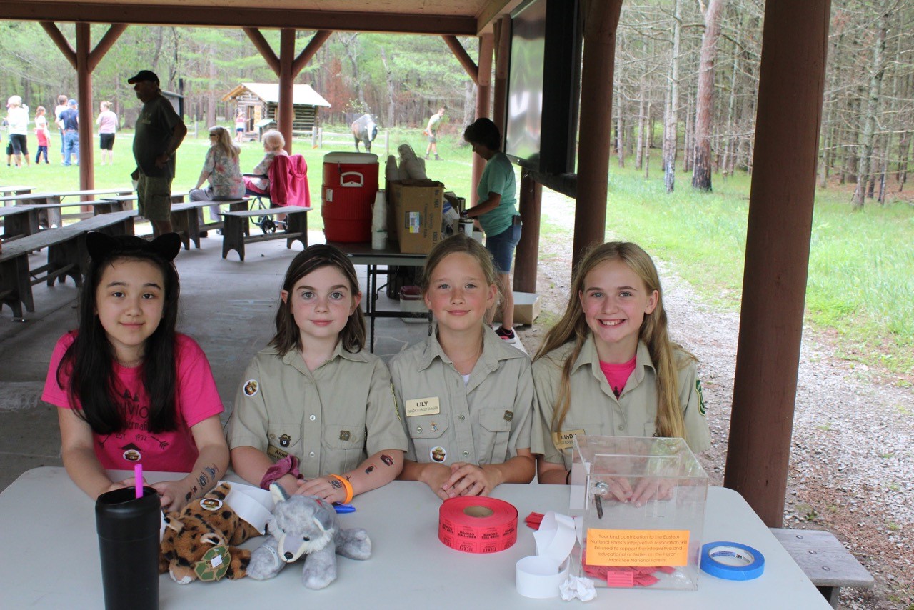 Four kids dressed as Junior Forest Rangers sitting at a table.