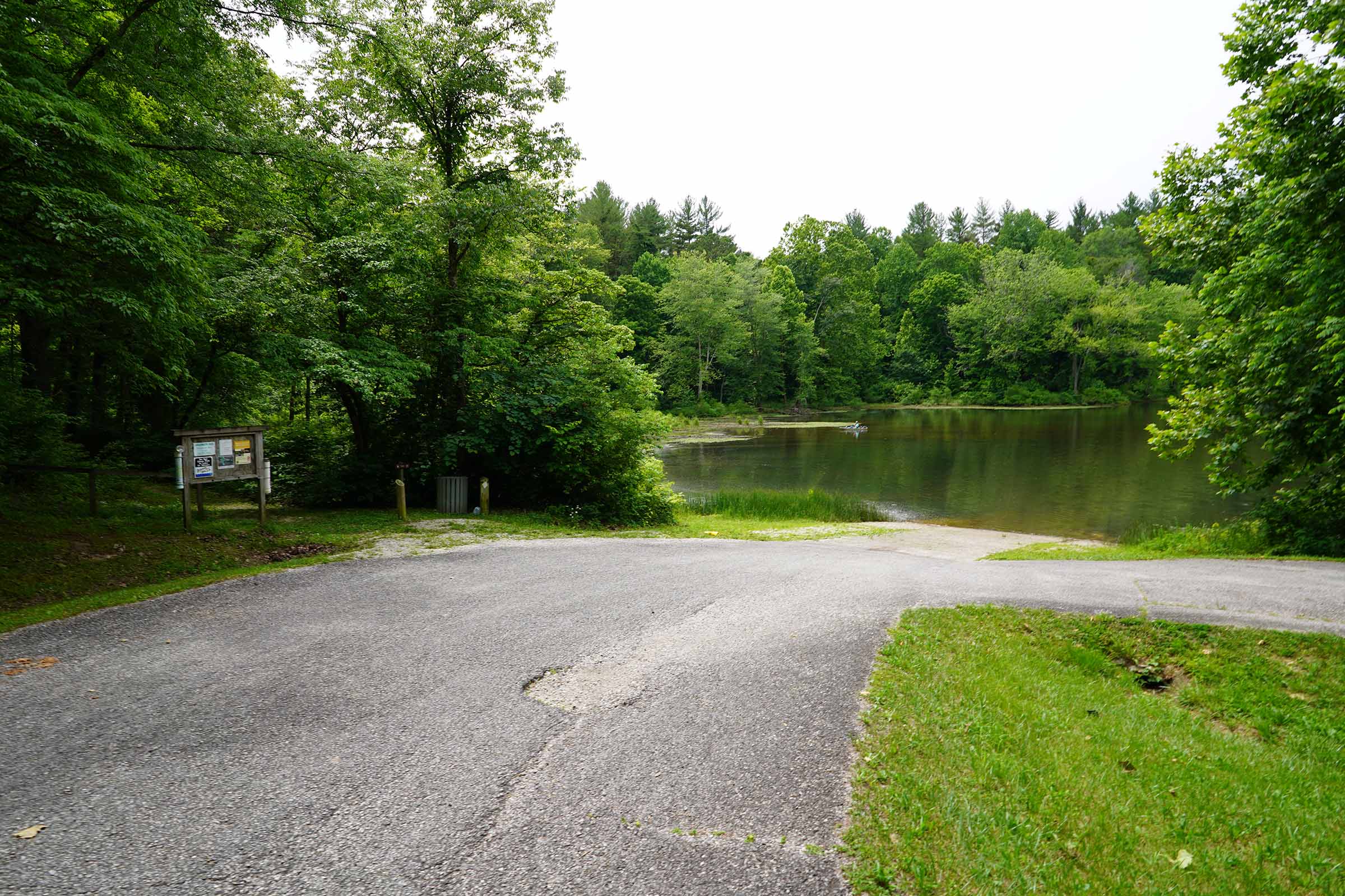 A paved boat ramp leads to a serene lake.