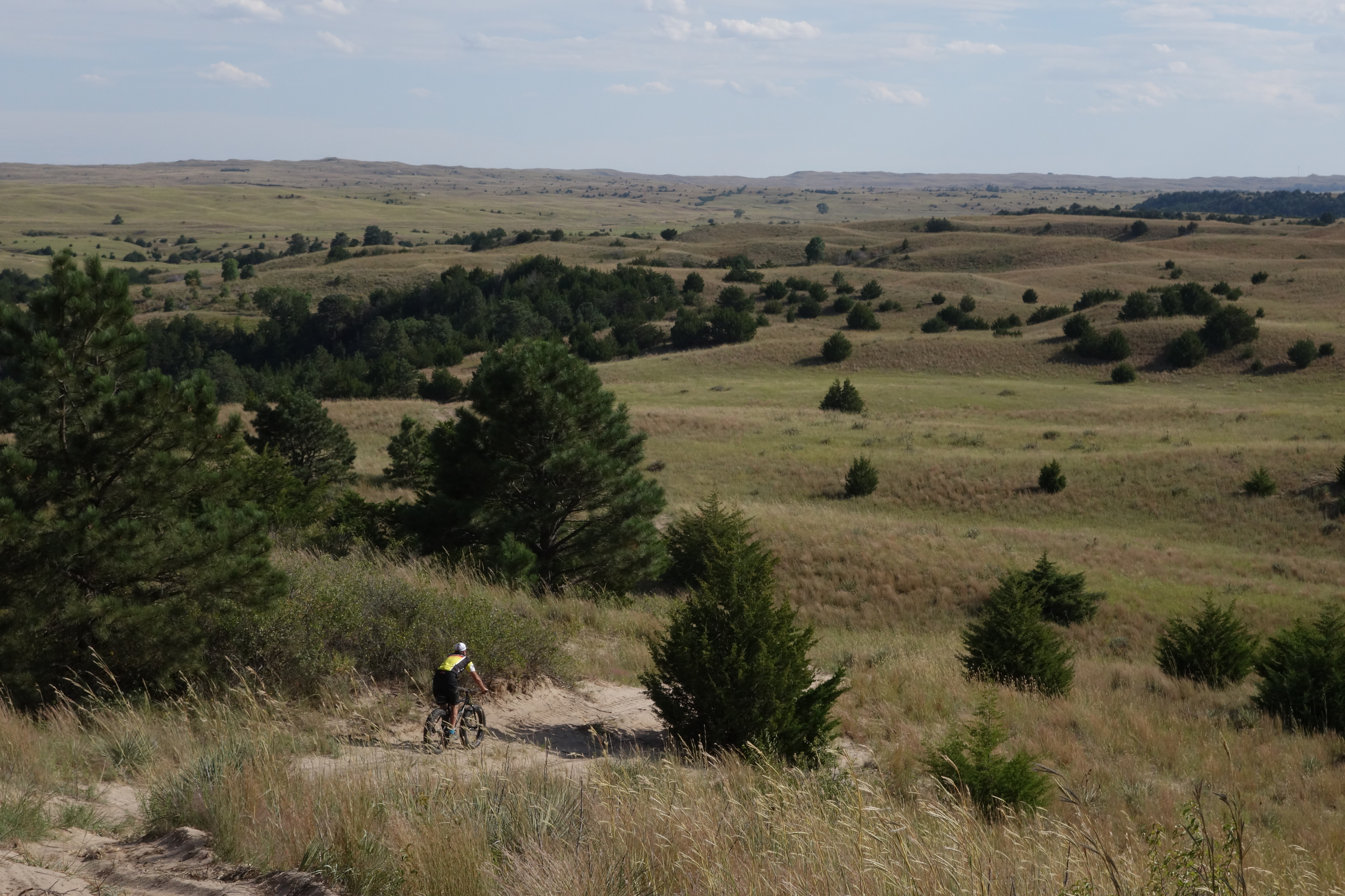 A lone mountain biker pedals up the sandhills.
