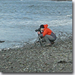 Irene Owsley photographing on a beach in Adak.