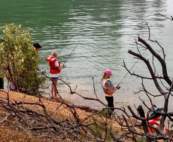 This photograph shows two young children fishing along the shore of Shasta Lake.