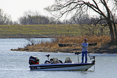 A boater takes time to do some fishing on Black Creek Lake on the LBJ National Grassland.
