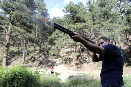 A man target shooting in the forest