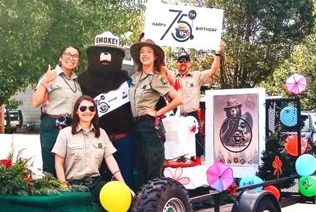 Forest Service employees gather on a float with Smokey Bear