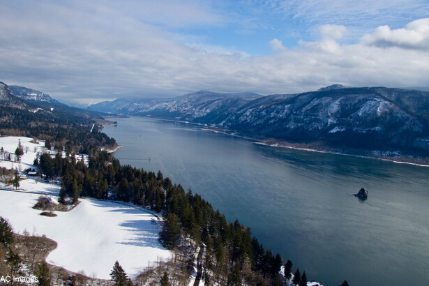 View of a large river gorge from above with snow visible on the adjacent hills and river banks.