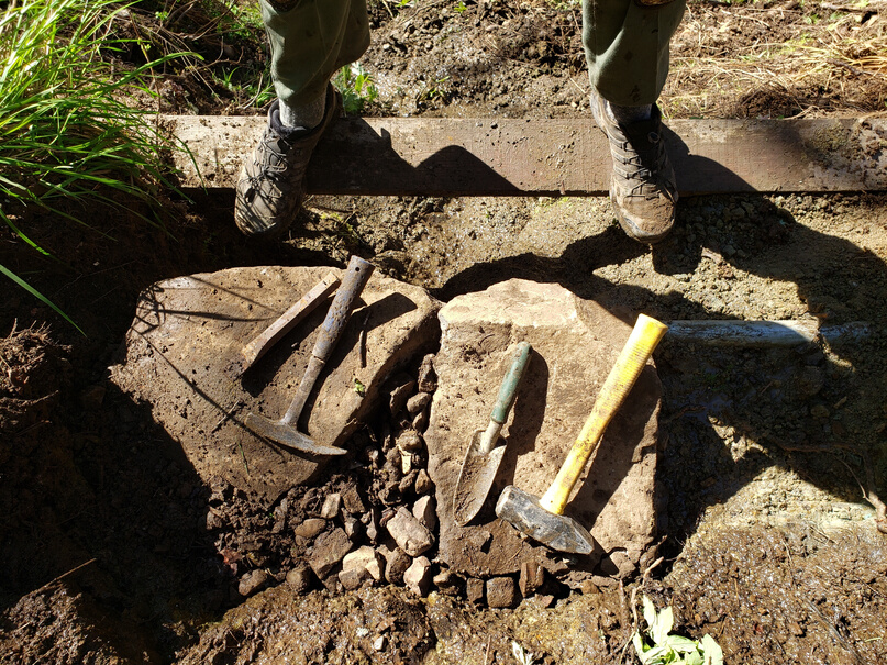 Photo of the feet with boots on with tools nearby
