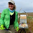 Pam Hanneman smiles with whale bones and paintings