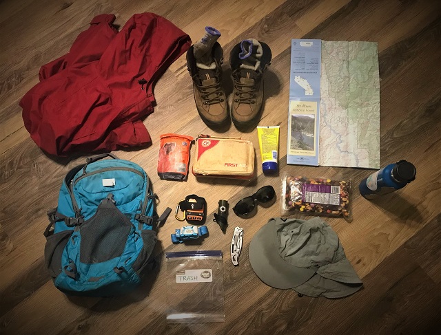 This photograph shows a backpack, first aid kit, water bottle, food, and other safety items.