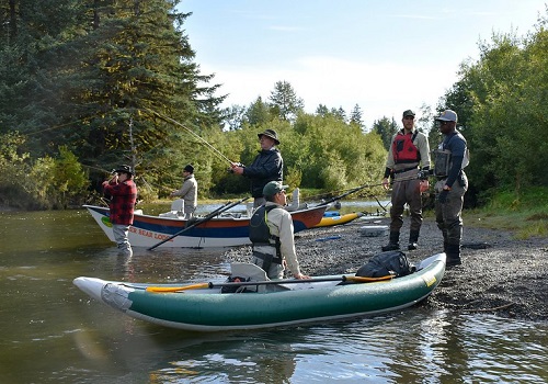 A forest ranger talks to a fishing guide on the river.