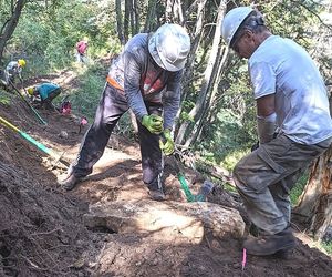 people in hardhats digging a new trail