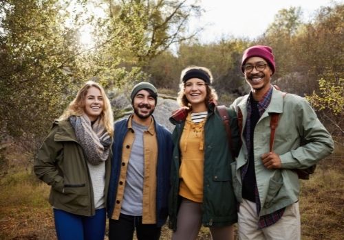 group of four people on a trail posing for a photo