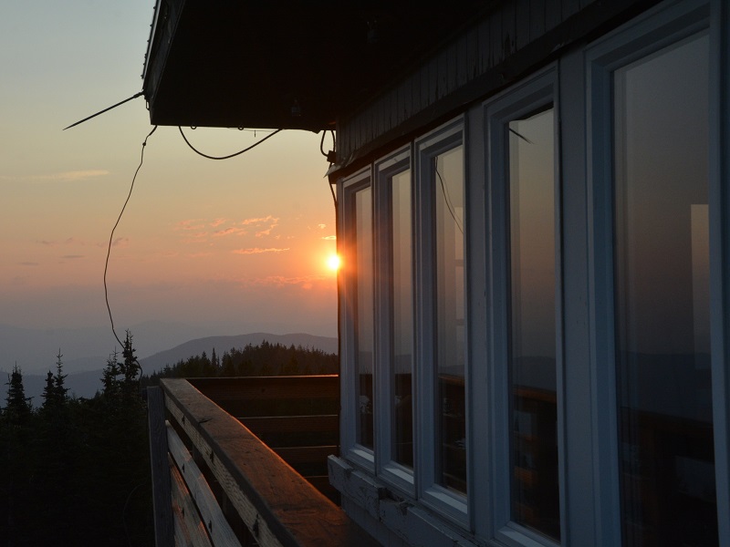 The sun setting behind a fire lookout tower