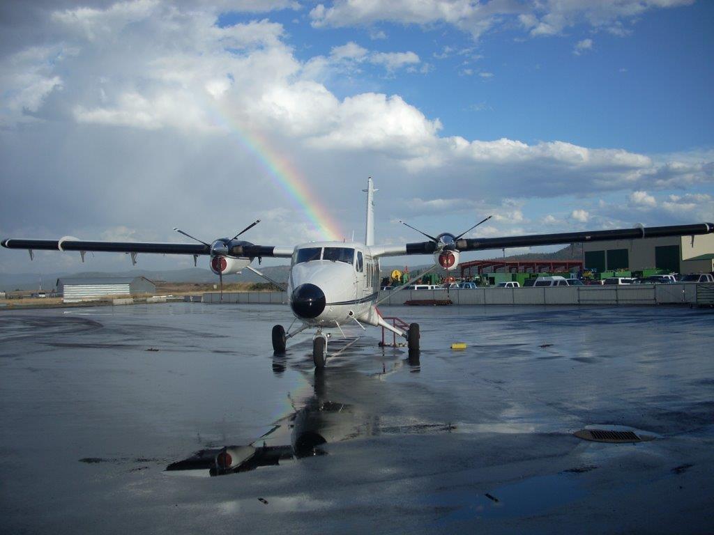 A small aircraft at the Grangeville Air Center with a rainbow behind it
