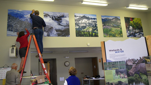 Photo of people hanging posters in the visitor center.