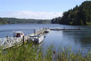View of boat ramp extending out into Tahkenich Lake with boats moored on both sides