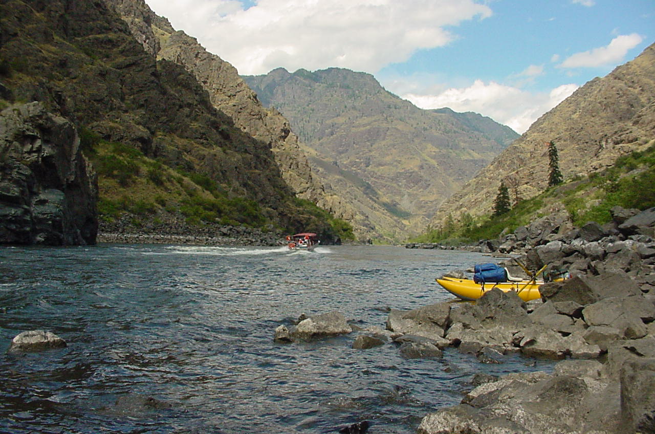 A small raft tied to the shore and and jetboat on the Wild and Scenic Snake River