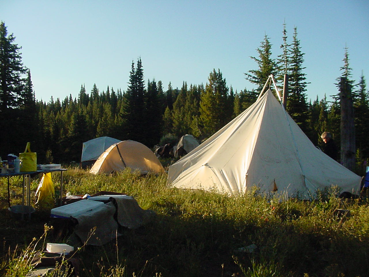 Wilderness camp with wall tents, tables and other gear