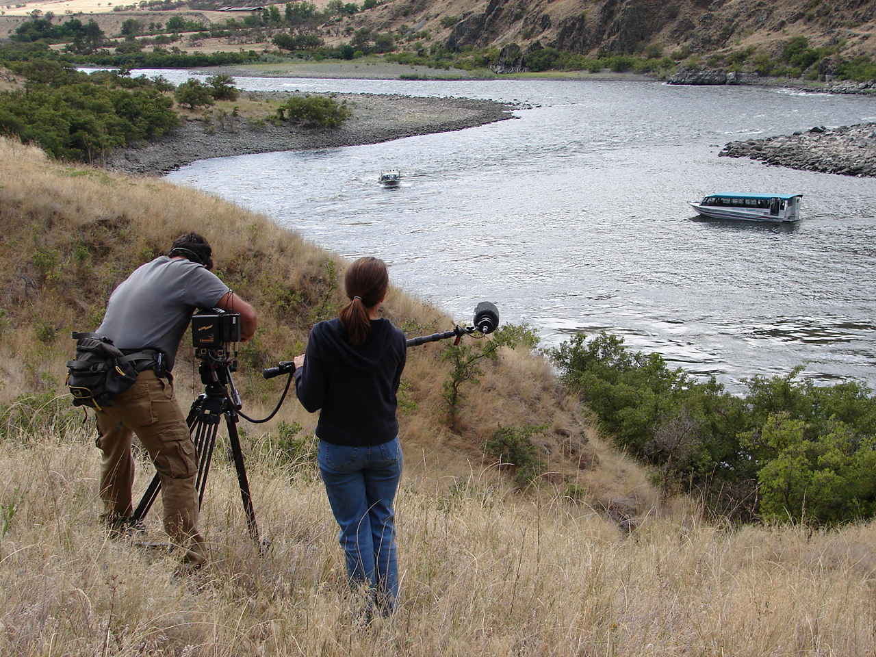 Man and women commercial filming a jetboat on the Snake River