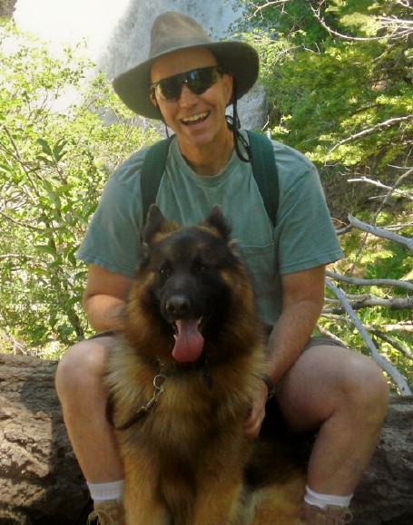 A man and his dog take a rest break on the trail.