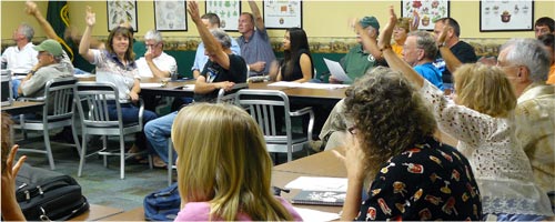 Participants in a recreation trails meeting raise hands to vote on an item of discussion.