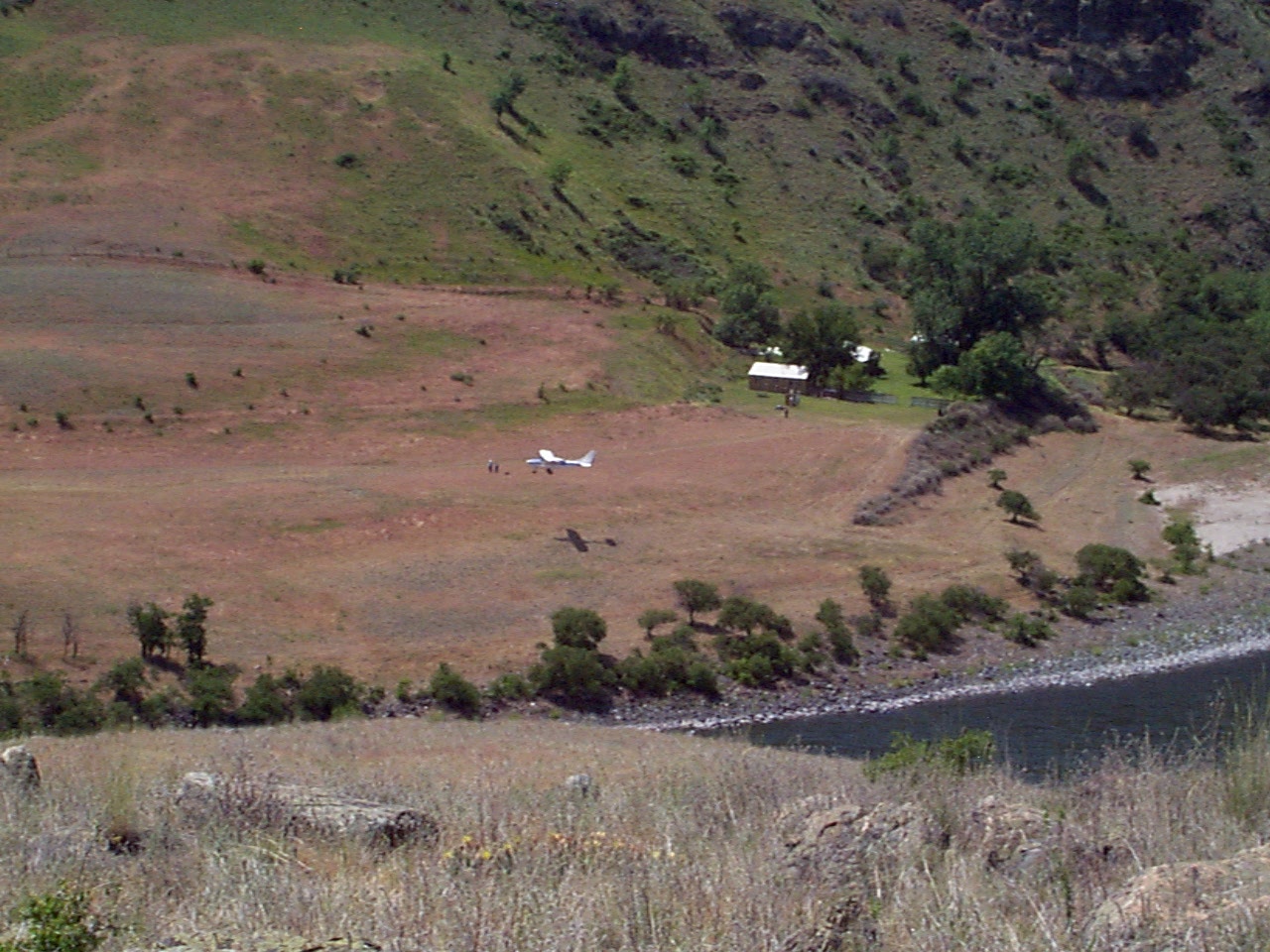 Airplane landing on a grassy backcountry airstrip at Pittsburg