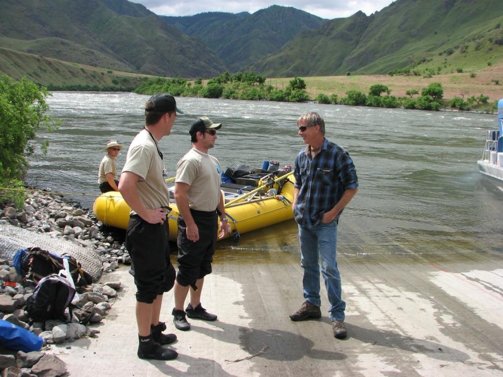 Forest Service river ranger talking with a man on a boat ramp