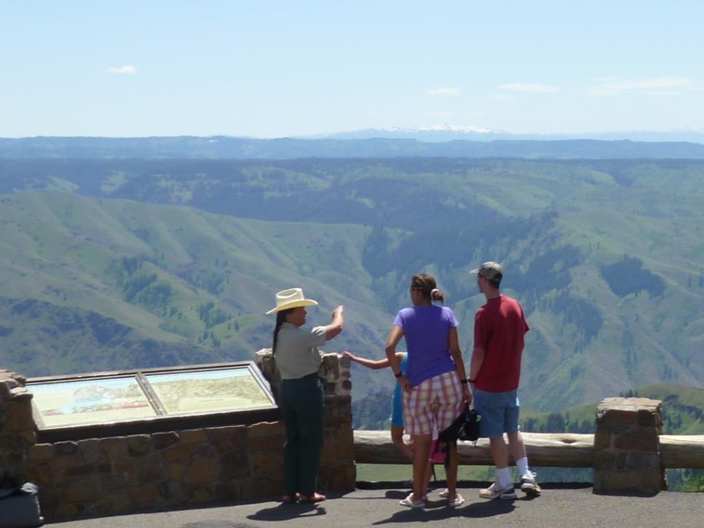 Forest Service employee talking with visitors at scenic overlook