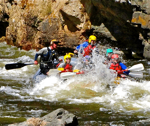 Rafters enjoying a run down a snowmelt-filled river in the Arapaho National Forest, located in central Colorado